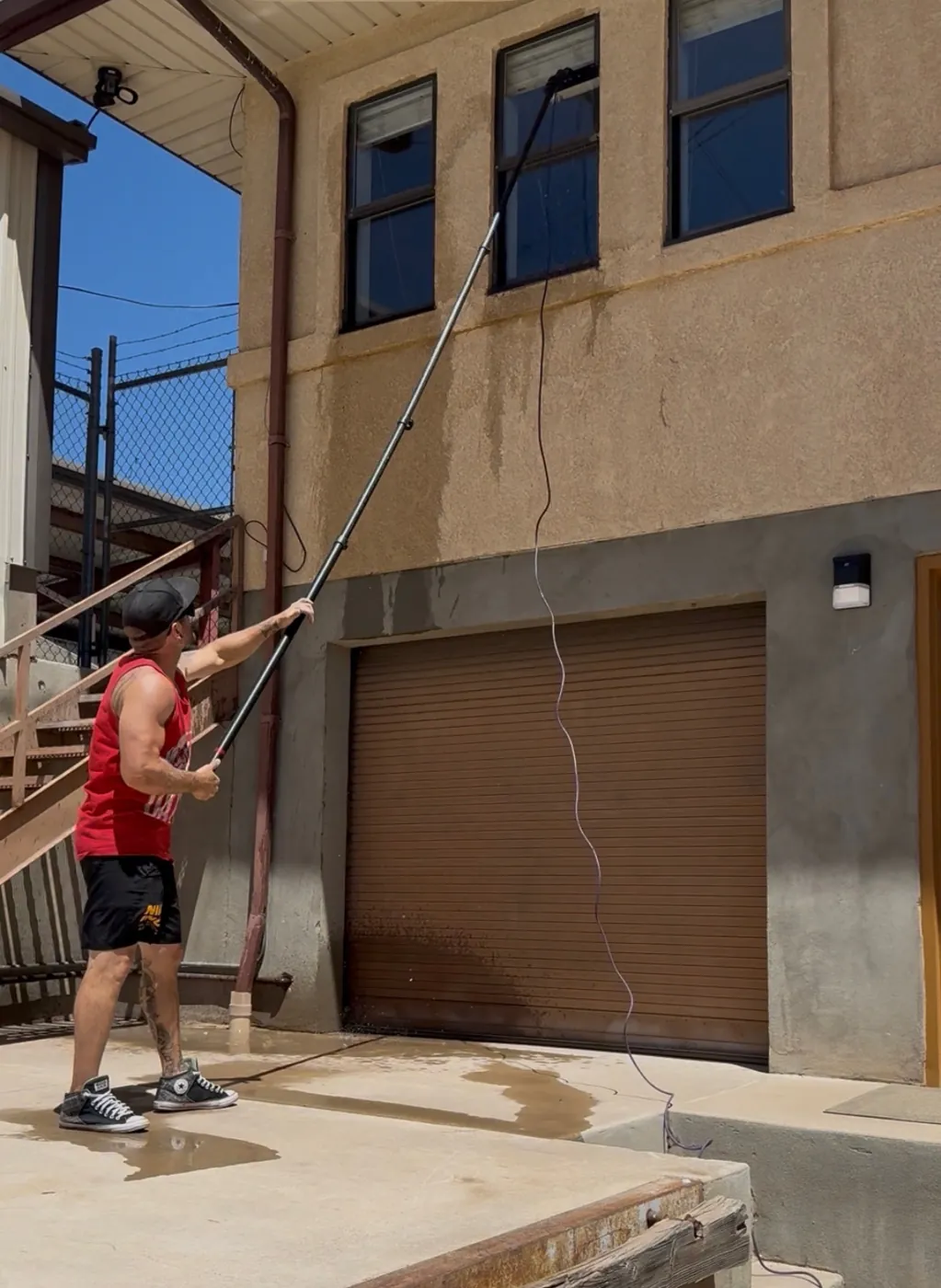 Zack Moffitt cleaning second-story windows with a water-fed pole