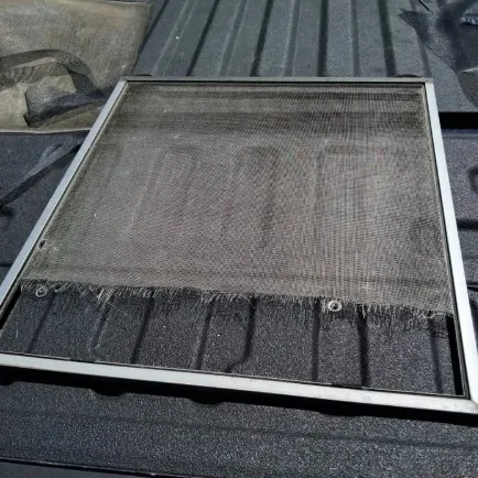 Old window screen with torn mesh before replacement