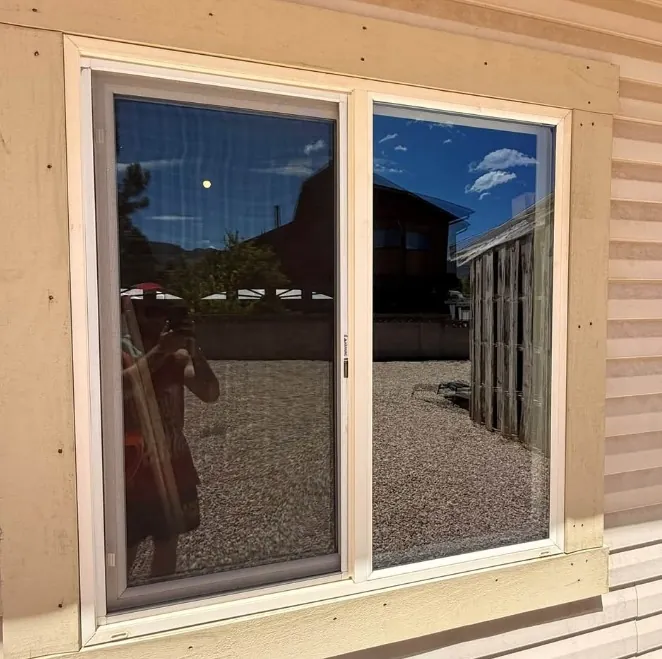 Clean sliding glass door reflecting the yard